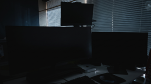 Dunkler Schreibtisch mit Monitoren
